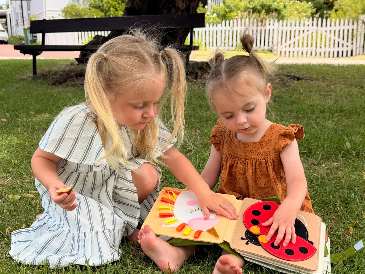 Two girls playing with a Cubby Busy Book